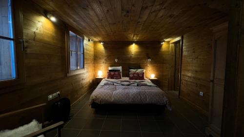 圣费朗索瓦-隆尚mini duplex dans chalet的木制客房内的一间卧室配有一张大床
