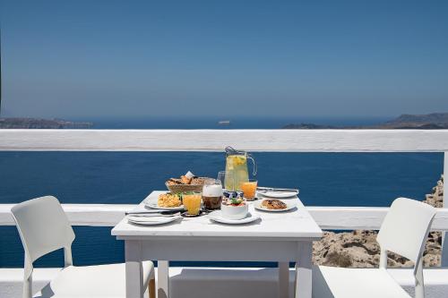 费拉Apeiron Blue Santorini - Sustainable Adults Only 14 Plus的阳台上的桌子上摆放着食物和饮料