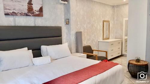 马盖特36 frere road shelly beach , margate的卧室配有一张大白色床和红色毯子