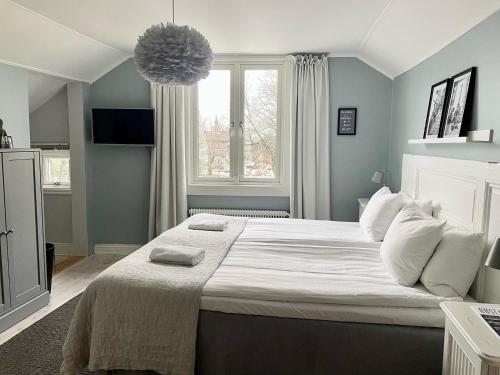 诺尔泰利耶Berglings Boutique Hotell的卧室配有一张大白色床和窗户