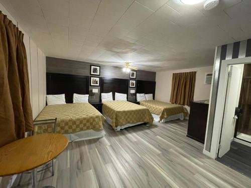 MinnedosaValley Motor Lodge的酒店客房设有两张床和一张桌子。