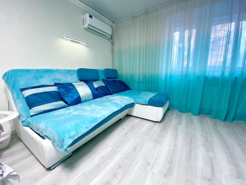 第聂伯罗Апартаменти завжди зі світлом的一间卧室配有蓝色的床和蓝色窗帘