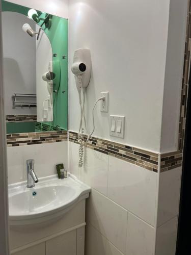 多伦多Adas Guesthouse的浴室配有水槽和墙上的吹风机