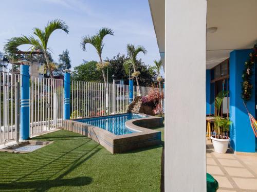 蒙塔尼塔Hotel Sol y Playa Montañita的一个带围栏和棕榈树的庭院内的游泳池