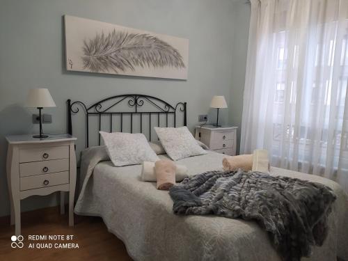 洛格罗尼奥Gonzalo de Berceo 15 " CALIDAD-SOBRIO" AND " FREE PRIVATE PARKING "的一间卧室配有一张床、两个床头柜和一张带毯子的床。