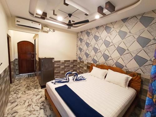 卡兰古特Richard Inn Residency的一间卧室配有一张带蓝白色毯子的床