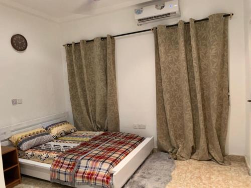阿克拉SUCCESS ROOM Ensuit - East Legon, Adjiringanor的一间卧室配有床和窗帘