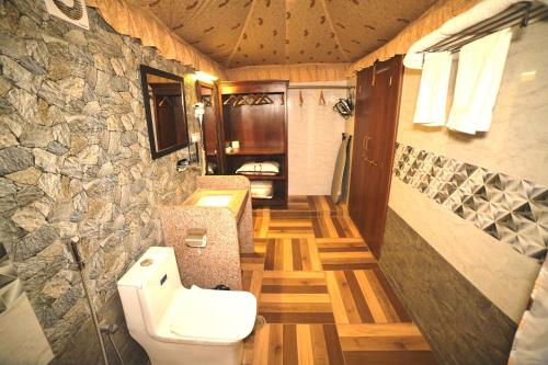 斋浦尔Amrit Van Resort的一间带卫生间和石墙的浴室