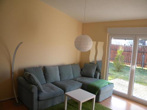 EllenhausenBusiness Apartment/Ferienwohnung (z. CGN/FFM)的客厅配有蓝色的沙发和桌子