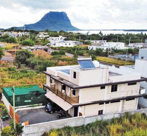 拉戈莱特Tenexia - Morne Brabant Studio的屋顶上设有太阳能电池板的房子,背景是一座山