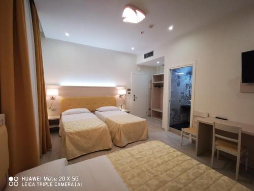 米兰Hotel Metropoli的酒店客房配有两张床和一张书桌