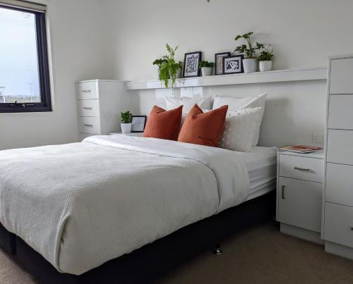 奥尔伯里The Botanical 304的卧室配有带枕头和植物的白色床