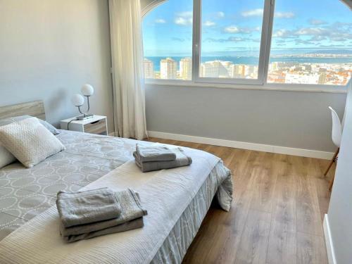 卡帕里卡海岸T2 com uma vista deslumbrante sobre o Atlântico!的一间卧室设有一张床和一个大窗户