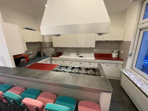 布鲁塞尔Le VILLAGE d'EZRA的厨房配有柜台和多彩的椅子