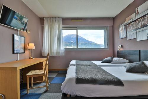 塞威恩乐思芙洛布鲁埃斯酒店的一间卧室设有两张床、一张桌子和一个窗口。