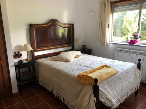 Moimenta da SerraQuinta das Oliveiras的一间卧室配有一张带木制床头板的床和窗户。