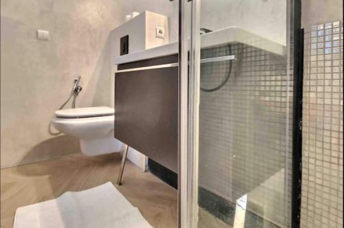 蒙特卡罗Beautiful Fully Renovated Centrally Located Studio的一间带卫生间和玻璃淋浴间的浴室