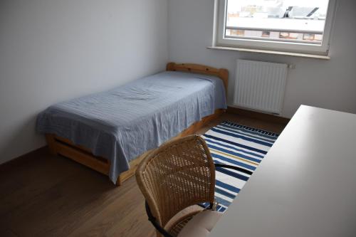 波兹南Uroczy apartament z widokiem i darmowym parkingiem的卧室配有床、椅子和窗户。