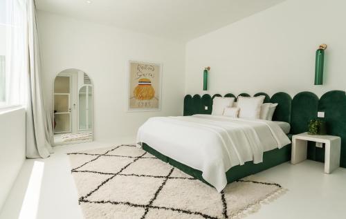 坎古The Cali Villas Canggu的一间卧室配有一张大床和绿色床头板