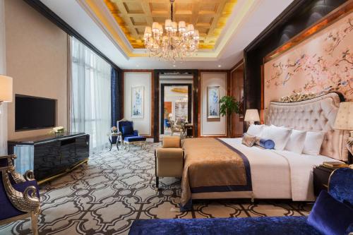 南昌南昌万达嘉华酒店的一间卧室配有一张大床和一个吊灯。