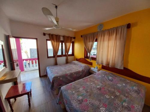 特科卢特拉Posada Casa Bugambilias的一间卧室设有两张床、一张桌子和窗户。