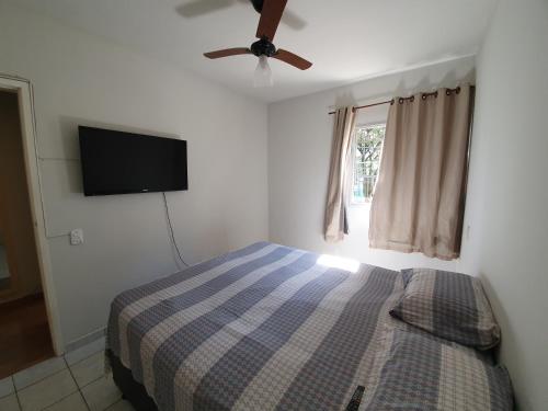 维多利亚Apto com dois quartos no bairro de Jardim Camburi的一间卧室配有一张床和一台平面电视