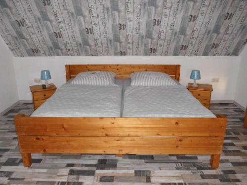 纽哈灵吉塞尔Möwennest的一间卧室配有木床和2个床头柜