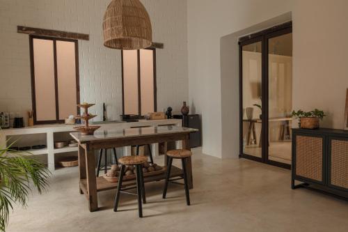 坎佩切Narrativ Lofts -Solario- Charming Historic Escape的厨房配有木桌和凳子