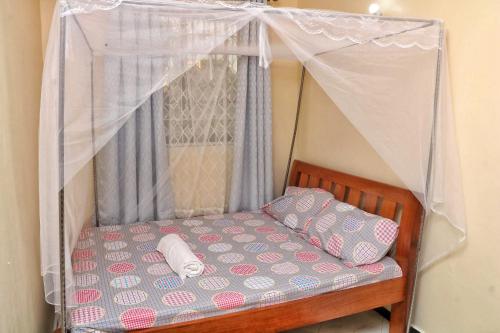 蒙巴萨Nice Spacious 1bedroom hideout in bamburi的一张带天蓬的床,上面有两个枕头