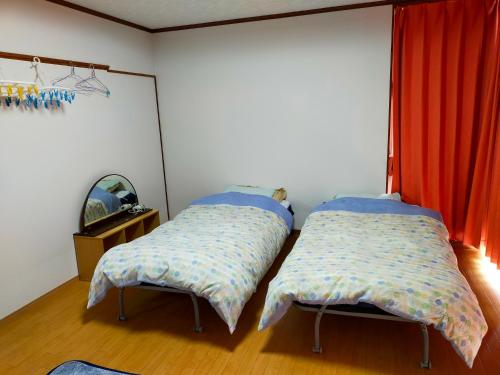 石垣岛碧海白保之宿旅馆的两张睡床彼此相邻,位于一个房间里