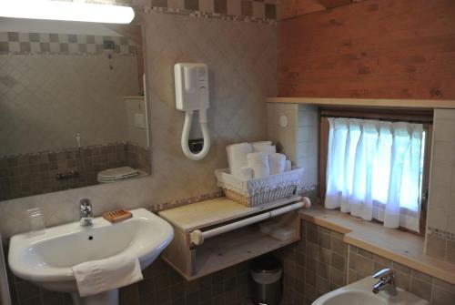 格雷索拉特里尼泰Hotel de Gletscher的一间带水槽的浴室和墙上的一部电话