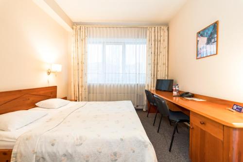 里加科隆纳布里格塔酒店的配有一张床和一张书桌的酒店客房