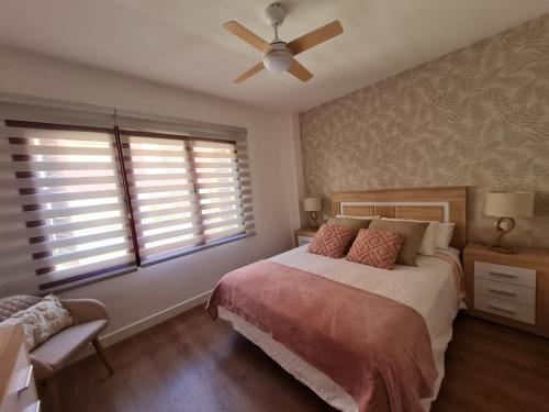 大加那利岛拉斯帕尔马斯Your Canary Home的一间卧室配有一张床和吊扇