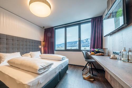 因斯布鲁克Rufi's Hotel Innsbruck的酒店客房配有两张床和一张书桌