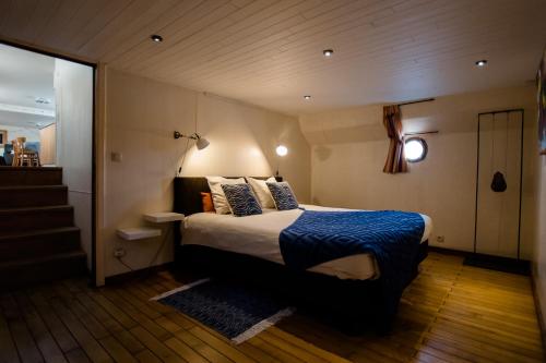 布鲁日Houseboat Jana - with sauna and terrace的一间卧室配有一张带蓝色毯子的床