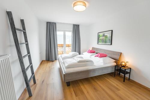 米尔施塔特诺瓦克公寓的一间卧室配有带粉红色枕头的床。