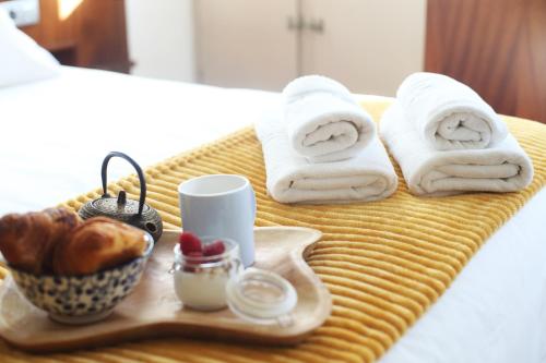 圣地亚哥－德孔波斯特拉圣克拉拉酒店的床上的托盘,上面有毛巾和面包