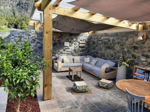 萨拉济La Croisee des Sentiers的一个带蓝色沙发和石墙的庭院