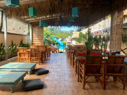 湄南海滩Samui Zenity的一间带木桌和椅子的餐厅以及游泳池