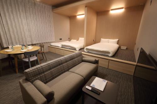 福冈White Crystal RoomA的酒店客房设有沙发、床和桌子。