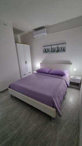 卡什泰拉Room Airport Split的一间卧室配有一张带紫色床单的大床