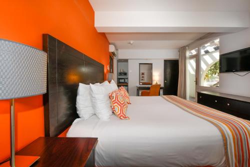奥拉涅斯塔德城镇讲谈海滩俱乐部酒店的一间卧室配有一张白色的床和橙色的墙壁
