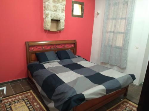 海法BenGurion 25 Apartment的红色墙壁的房间里一张床位