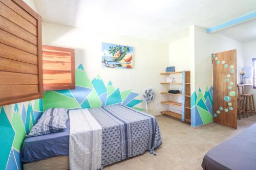 皮帕Back to the Beach Hostel - Pipa的一间卧室配有一张蓝色和绿色墙壁的床