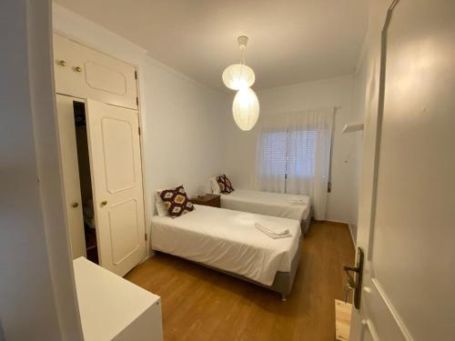 纳扎雷Zulla House的一间小卧室,配有两张床和窗户