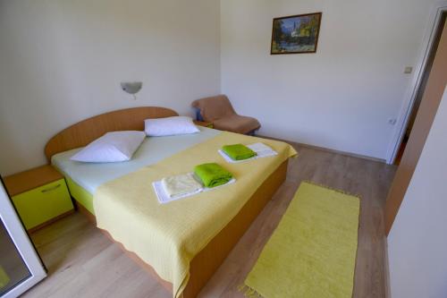 苏佩塔斯卡德拉加Apartmani Zlata的一间卧室配有一张带两张绿毛巾的床