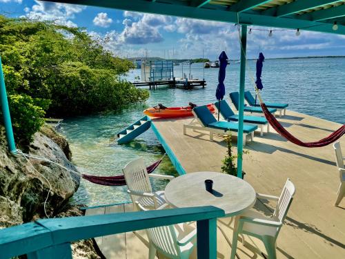 奥拉涅斯塔德Vistalmar Ocean Suites的一个带桌椅和水的庭院