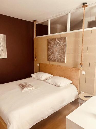 勒克佐Suite 24 Appart'hôtel-3 étoiles的一间卧室配有两张带白色枕头的床