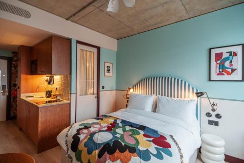 伦敦room2 Chiswick Hometel的一间卧室配有一张大床和色彩缤纷的毯子
