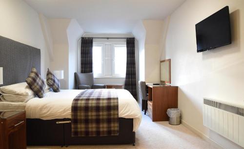 波特里皇家酒店的一间酒店客房,配有一张床和一台电视